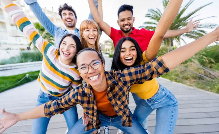 a diverse group of young adults smiling outside